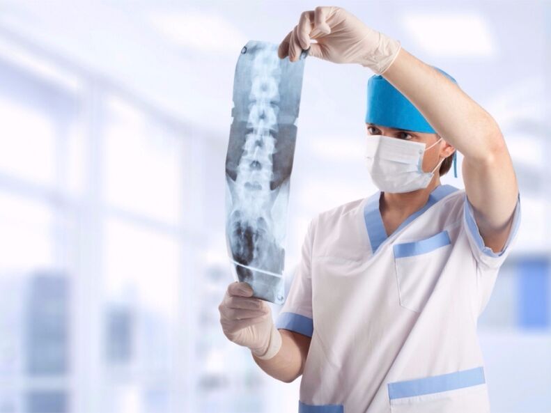 the doctor looks at a snapshot of the cervical spine with osteochondrosis